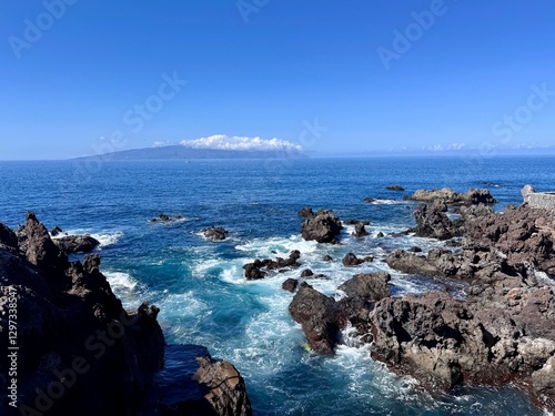 Schilderij op canvas Seascape with La Gamora on the horizon, blue sea and sky and rocks