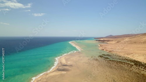 drone rises above white sand ocean beach