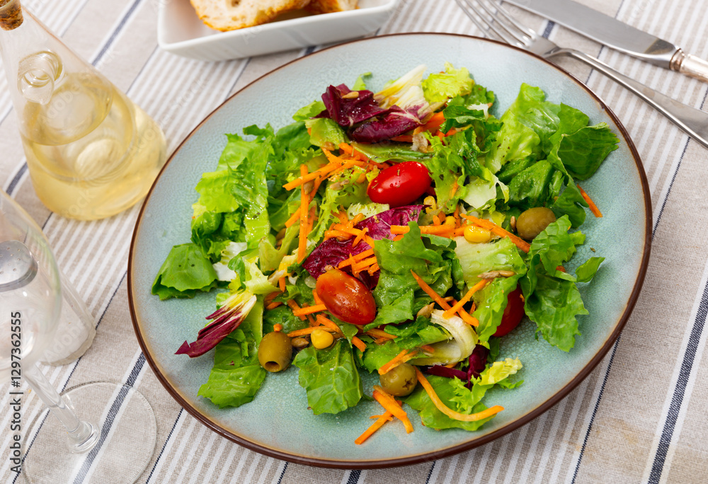 Summer mixed salad of carrot, lettuce, tomatoes and olives closeup Summer mixed salad of carrot, lettuce, tomatoes and olives closeup