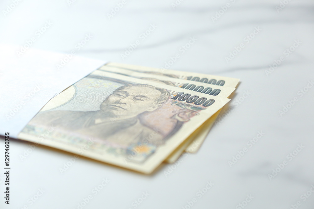 封筒に入った一万円の紙幣とコピースペース
封筒に入った一万円の紙幣とコピースペース