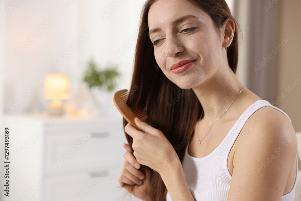Beautiful woman brushing her hair with comb at home, space for text Beautiful woman brushing her hair with comb at home, space for text