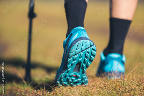 Fitness woman legs walking on high altitude grassland mountain road photo