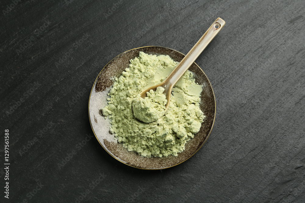 Plate with dry wasabi powder and spoon on dark textured table, top view Plate with dry wasabi powder and spoon on dark textured table, top view