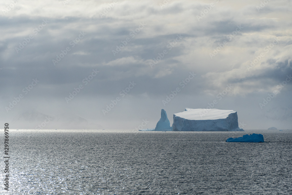 Φωτογραφία A tranquil Antarctic landscape, near Graham passage along Charlotte Bay, highlighting stark reflections, rugged mountains, and impressive icebergs