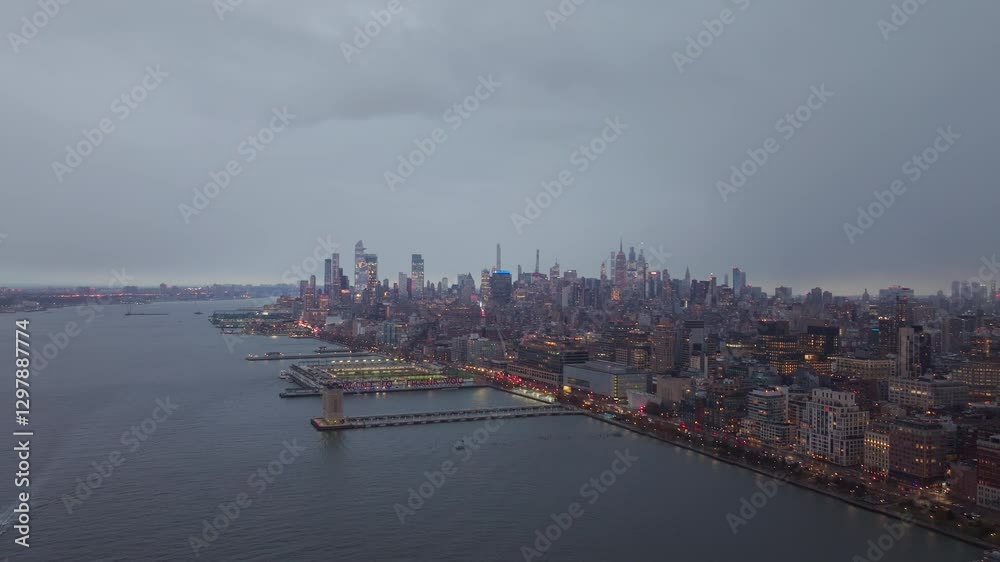 Lower Manhattan skyline with cloudy sky at dusk, featuring the Hudson River and urban landscape from aerial perspective Lower Manhattan skyline with cloudy sky at dusk, featuring the Hudson River and urban landscape from aerial perspective