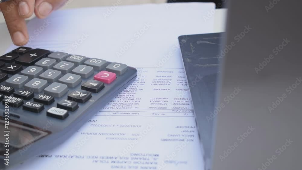 Banking business financial accounting concept. An Asian man pressing calculator keys while working at office desk. Financial accounting. Banking business financial accounting concept. An Asian man pressing calculator keys while working at office desk. Financial accounting.