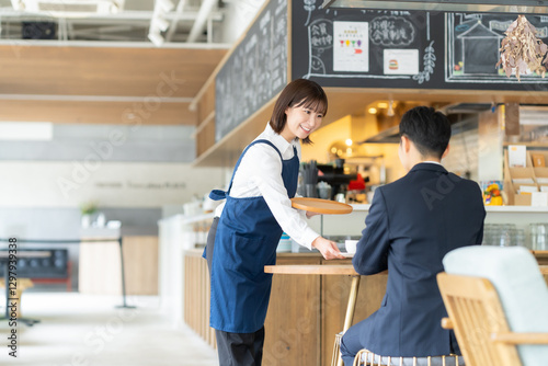 カフェでビジネスマンを接客する女性の店員