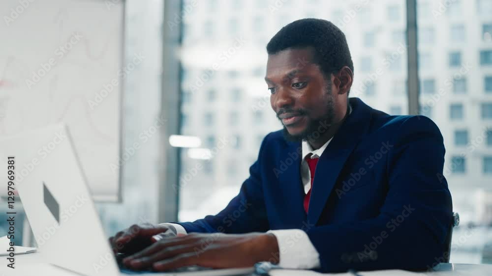 Office worker finished important financial report and smiling looking at laptop. Portrait of black businessman working with computer in modern office of big company or co-working, relax after work Office worker finished important financial report and smiling looking at laptop. Portrait of black businessman working with computer in modern office of big company or co-working, relax after work