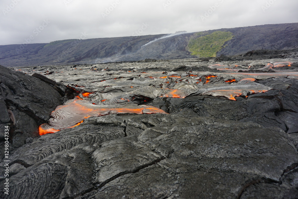 Naklejka premium Active lava flows over old lava field in Hawaii