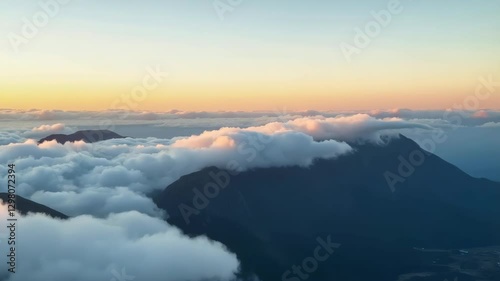 Wallpaper Mural A landscape photograph capturing a breathtaking aerial view of a mountainous region enveloped in clouds, with soft and diffused lighting, creating a serene and tranquil atmosphere Torontodigital.ca