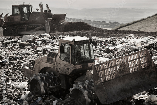 Obraz na płótnie Heavy machinery shredding garbage in an open air landfill. Pollution w salonie