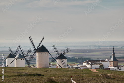The iconic windmills of Campo de Criptana, famously linked to Don Quixote, standing against the vast Castilian landscape in Castilla-La Mancha, Spain photo