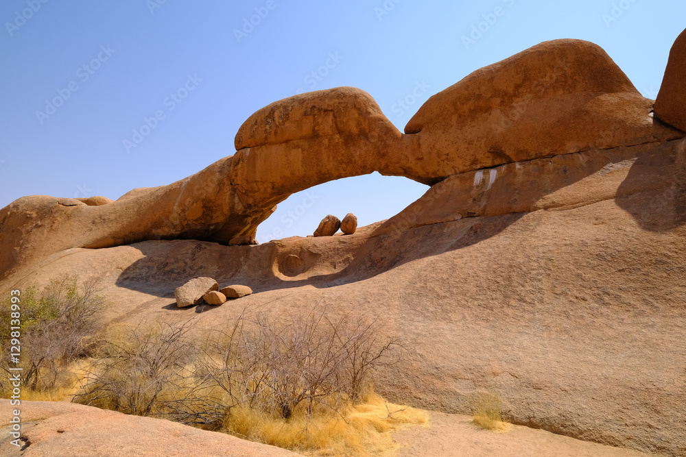 The iconic Spitzkoppe Arch in Damaraland, Namibia, a stunning natural rock formation shaped by erosion over millions of years. The iconic Spitzkoppe Arch in Damaraland, Namibia, a stunning natural rock formation shaped by erosion over millions of years.