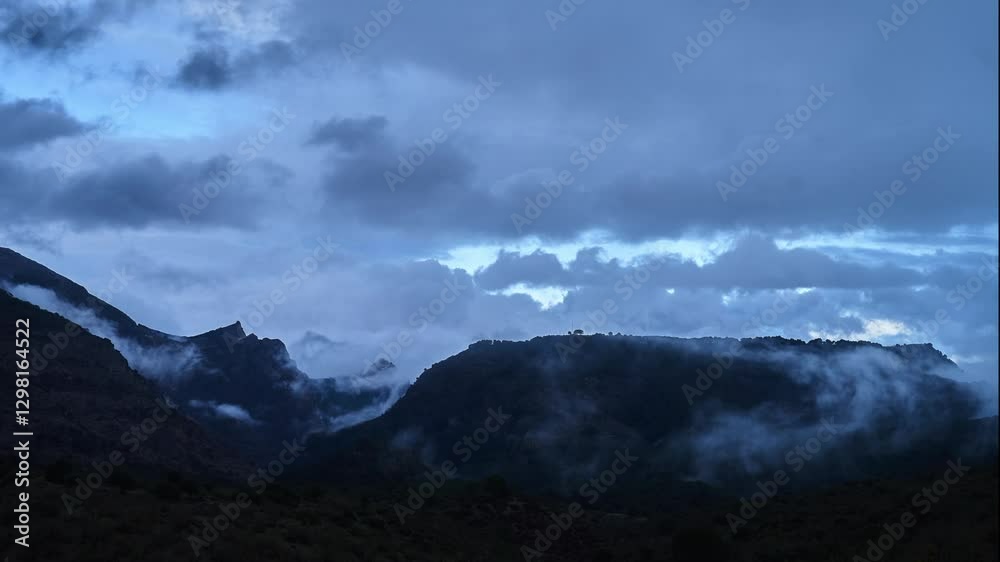 Drone time lapse of fog and clouds floating around mountain at dawn in Andalusia, Spain Drone time lapse of fog and clouds floating around mountain at dawn in Andalusia, Spain