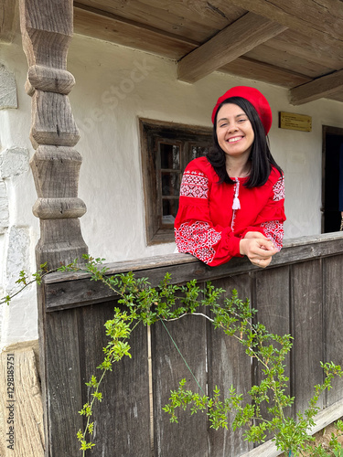 Obraz na płótnie Smiling Woman in Traditional Red Outfit by Rustic Window w salonie