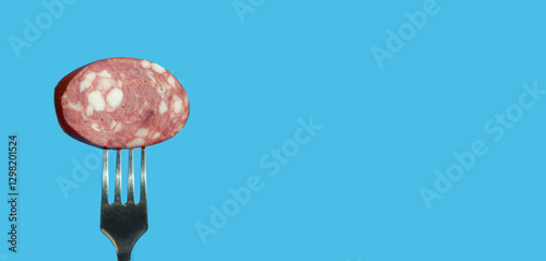 a piece of meat sausage with bacon on a metal fork. background for the design. the blue color.