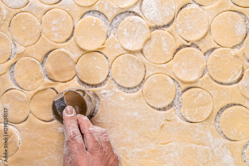 Fotografie Cutting circles of dough a metal round shaped knife