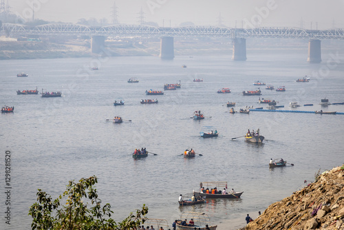 pilgrims on boat crossing sacred ganges river for triveni sangam at mahakumbh photo
