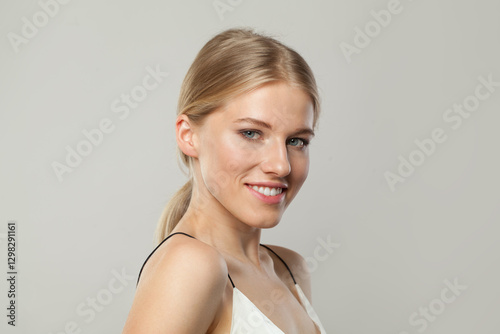 Beautiful blond model woman portrait. Beauty face with healthy clear skin, long shiny hair and cute smile
