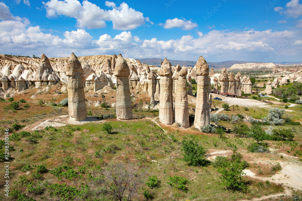 Ancient rock formations rise majestically in Cappadocia under a bright blue sky.