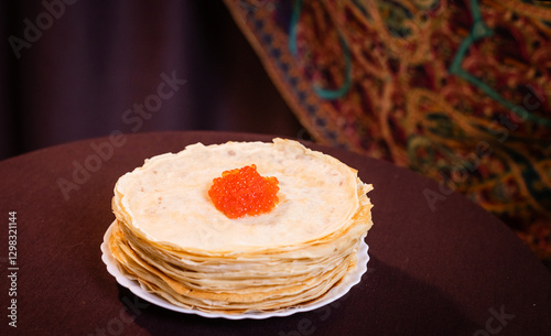 lots of delicious, mouth-watering pancakes with red caviar for Russian Maslenitsa.