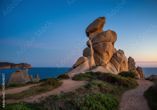 Balanced rock formation on a coastal trail at twilight, breathtaking geological structure, AI-generated landscape. photo