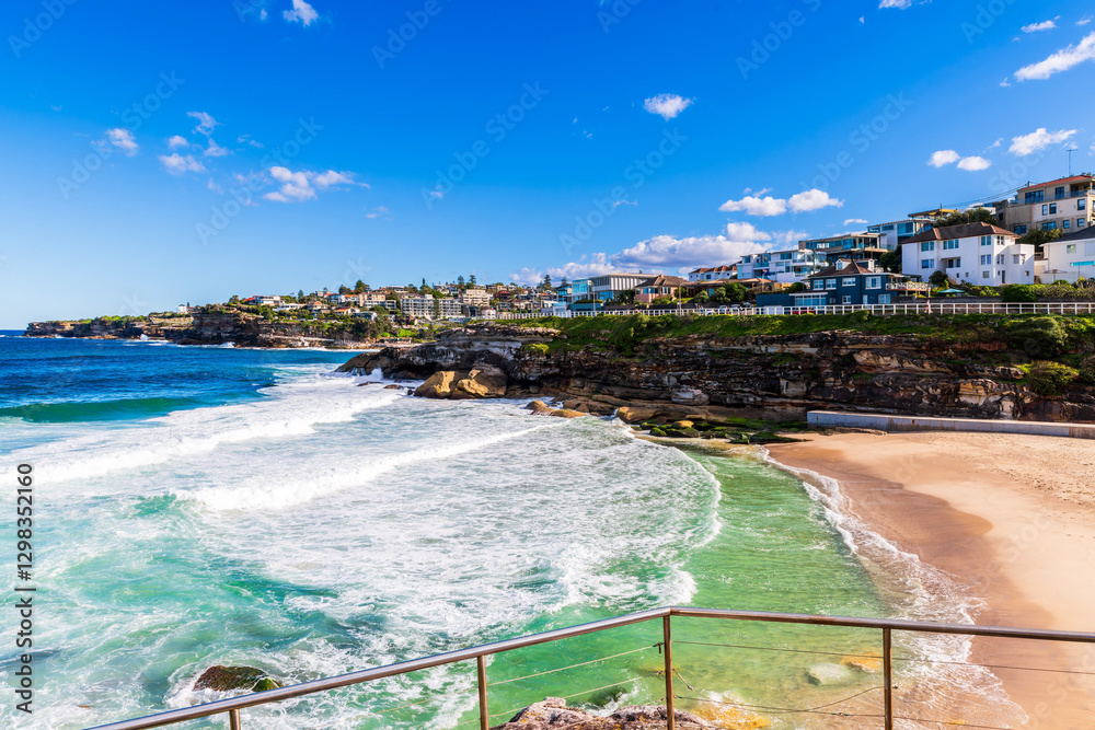 Fototapeta premium Tamarama Beach with houses along shoreline on a bright day, Sydney, Australia