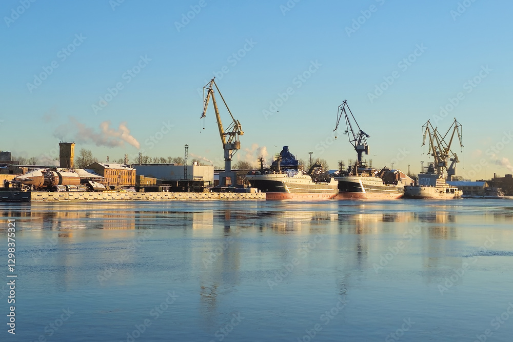 Obraz premium Moored ship and harbour cranes in port on Neva river