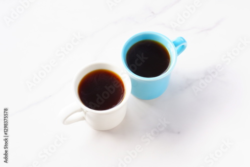 淹れたてのコーヒーが入ったふたつのマグカップで、ふたりがコーヒーを飲みながら、打ち合わせをしているイメージ
 photo