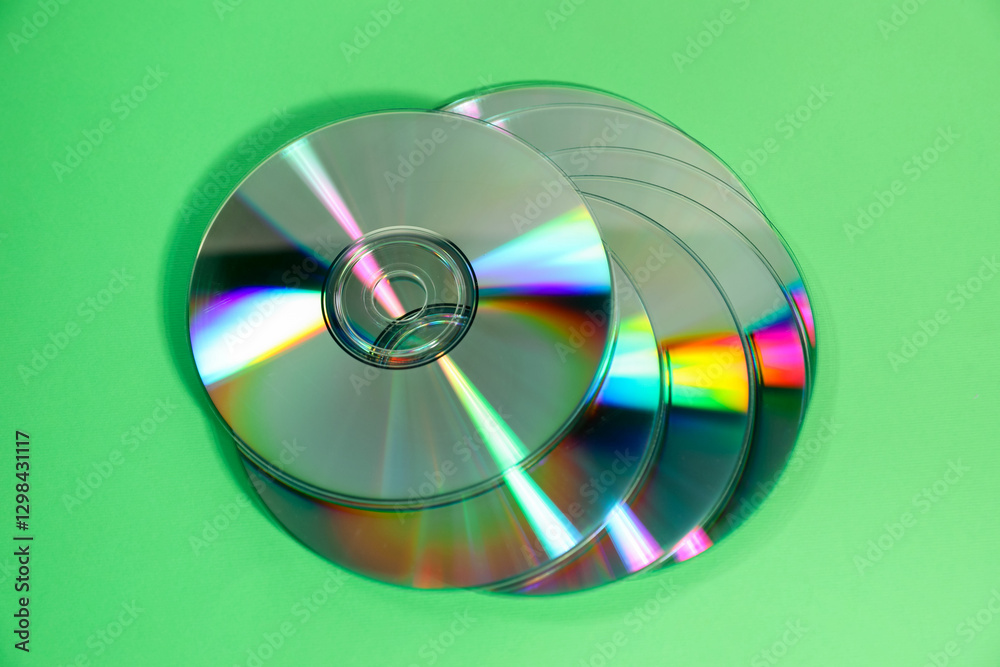 Many compact discs on green background, top view Many compact discs on green background, top view