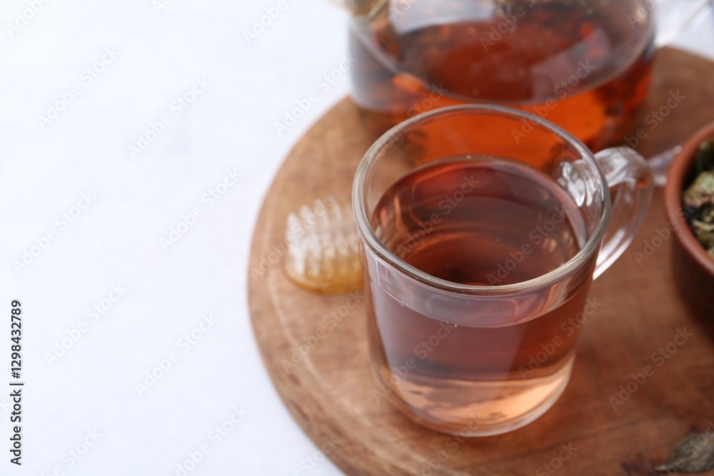Delicious herbal tea with honey on white table. Space for text Delicious herbal tea with honey on white table. Space for text