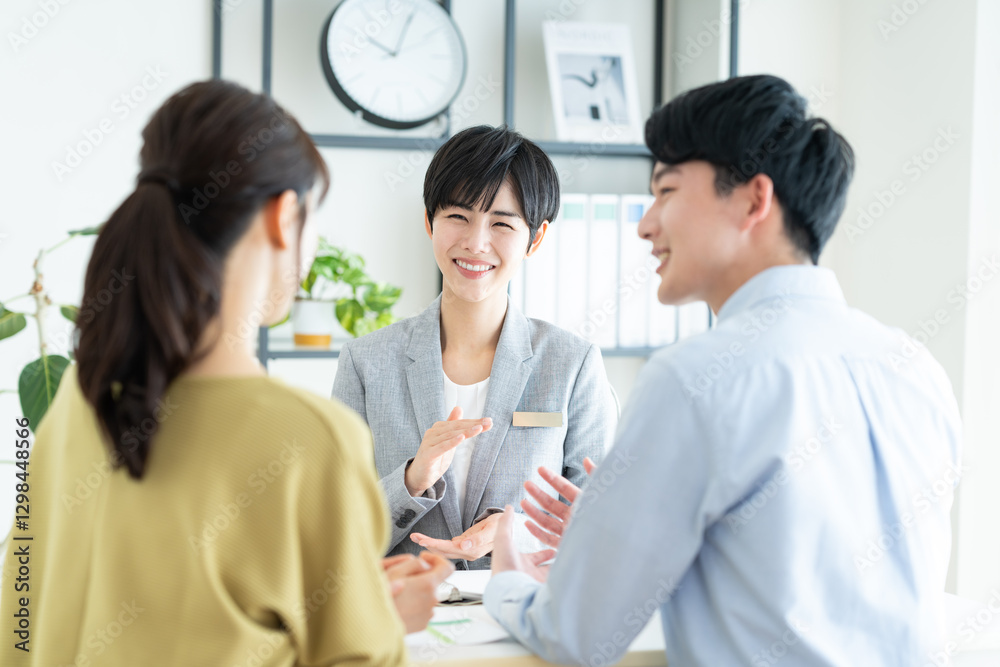 若い夫婦に営業するビジネスウーマン 若い夫婦に営業するビジネスウーマン