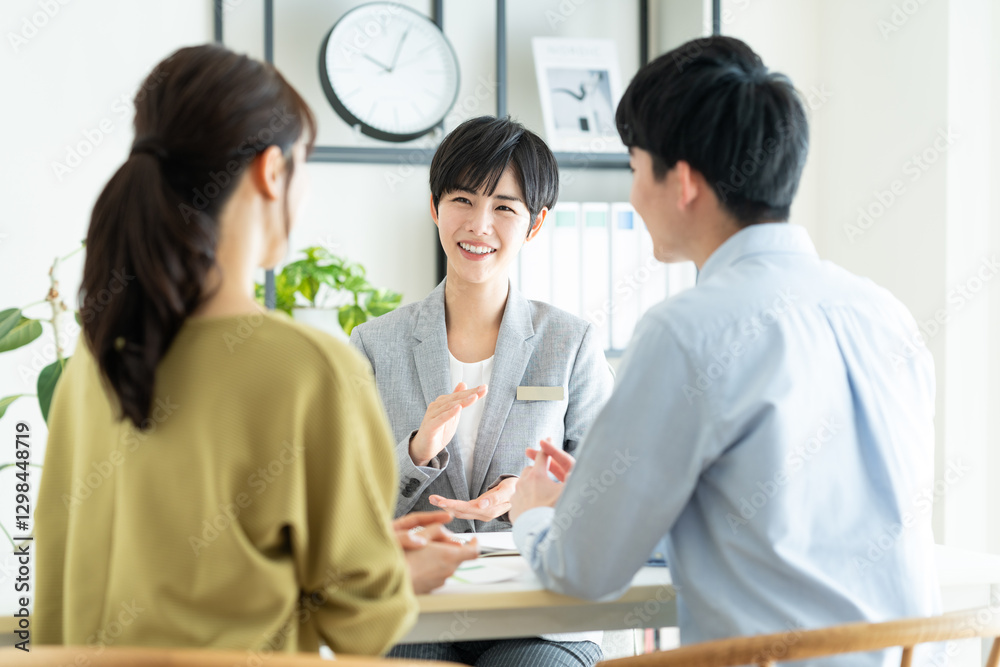 Fototapeta premium 若い夫婦に営業するビジネスウーマン