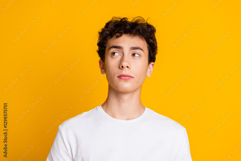 Portrait of a Young Man in a White T-shirt Posing Against a Vibrant Yellow Background with a Thoughtful Expression Portrait of a Young Man in a White T-shirt Posing Against a Vibrant Yellow Background with a Thoughtful Expression