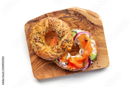 Lox bagel. A sandwich with smoked salmon and fresh vegetables on a wooden board on a white background, overhead flat lay shot