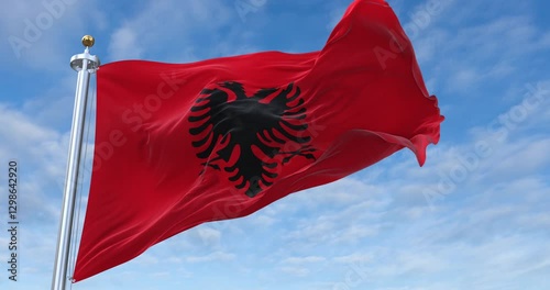 Albania flag with flagpole waving in wind, rolling clouds background looping, 4K video (Perfect Loop)