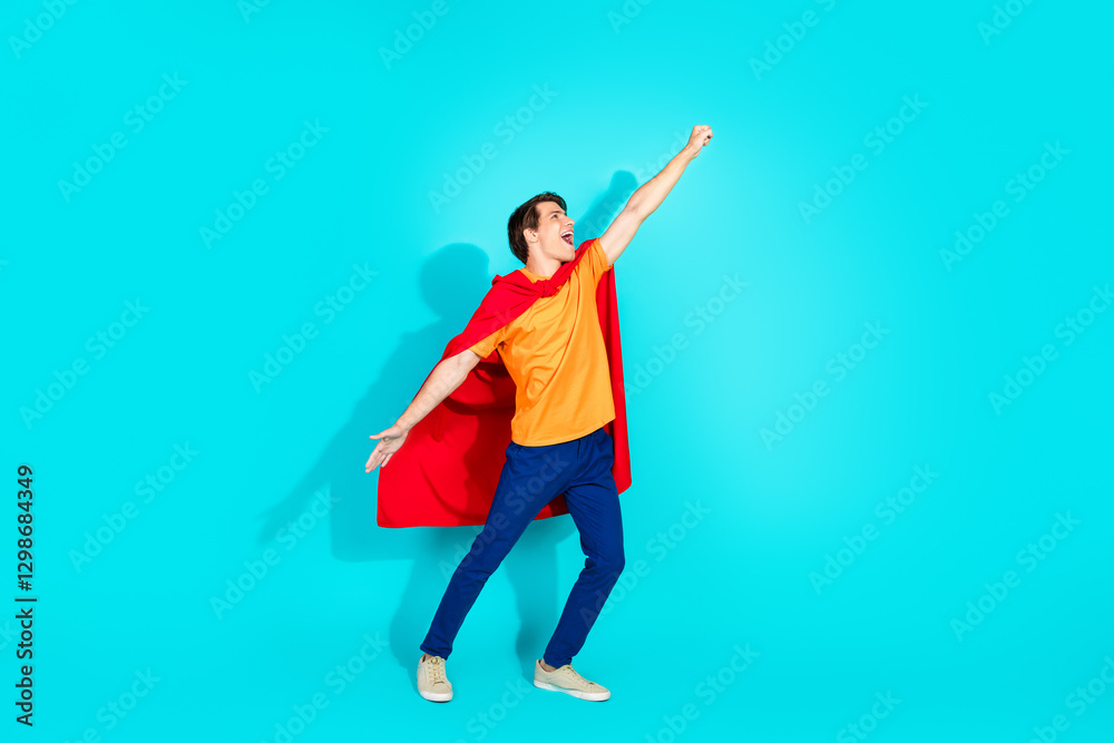 Confident young man poses as superhero in vibrant casual attire against a bright teal background symbolizing confidence and imagination Confident young man poses as superhero in vibrant casual attire against a bright teal background symbolizing confidence and imagination