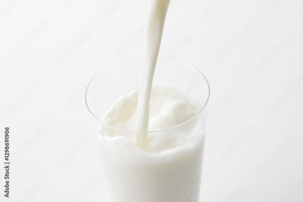 白い背景とグラスに注いだ牛乳 Milk poured into a glass with a white background 白い背景とグラスに注いだ牛乳 Milk poured into a glass with a white background