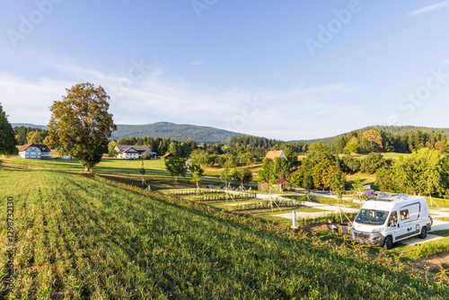 Buscamper parked at modern camping at the country site of Stiermarken region in Austria