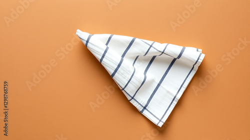Folded linen striped kitchen towel on brown background, top view