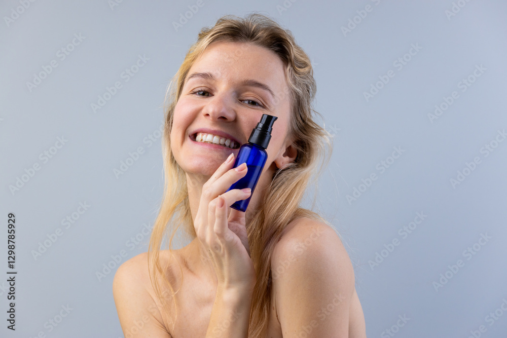 A Happy Young Woman Delightfully Posing with a Skincare Product in a Blue Container, Highlighting Natural Beauty and a Refreshing Skincare Routine A Happy Young Woman Delightfully Posing with a Skincare Product in a Blue Container, Highlighting Natural Beauty and a Refreshing Skincare Routine