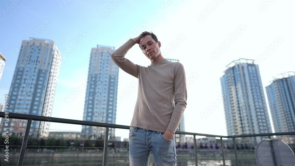 A fashionable and stylish young man stands confidently and poised with tall skyscrapers in the vibrant background A fashionable and stylish young man stands confidently and poised with tall skyscrapers in the vibrant background