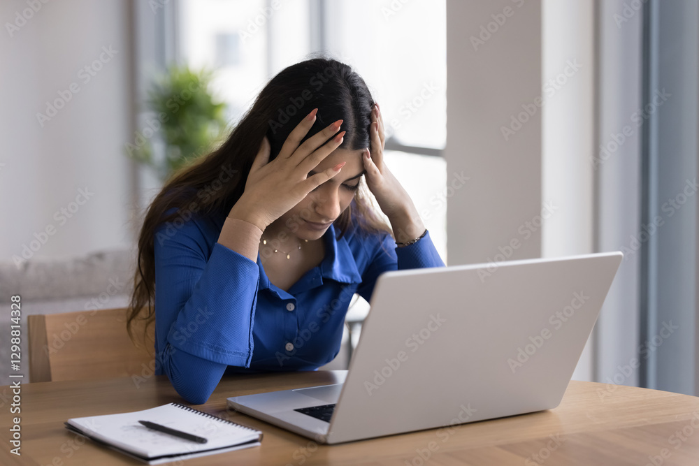 Young woman sit at desk with laptop, touch her head with hands looks burdened by workload, experiencing work-related pressure or burnout, get awful news or feel unhealthy due to information overload Young woman sit at desk with laptop, touch her head with hands looks burdened by workload, experiencing work-related pressure or burnout, get awful news or feel unhealthy due to information overload