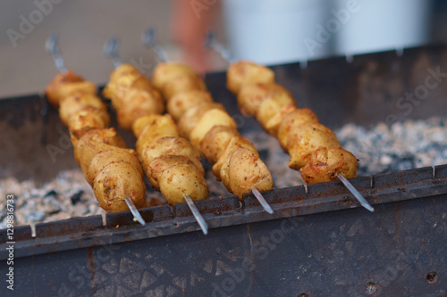 shashlik of potatoes and meat. vegetarian concept. grill with coals and vegetables on skewers.