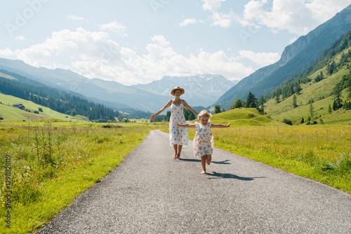 Mother and daughter in green nature. Healthy family outdoors. Woman with little girl in meadow.