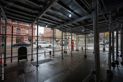 Passing under scaffolding near buildings on a street in New York