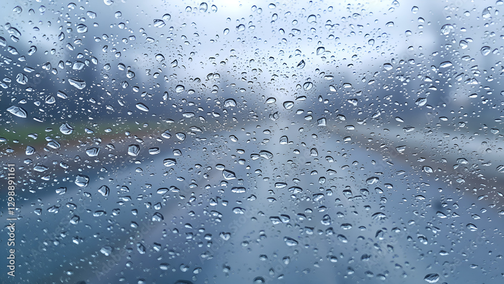 Obraz premium Windshield with moisture and water droplets with road in the background