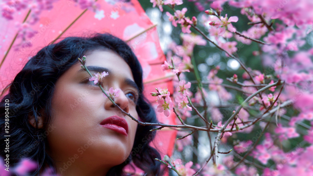 Beautiful woman smelling almond and cherry blossoms in spring