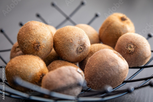 Fototapeta Naklejka Na Ścianę i Meble -  Kiwi in a bowl. Unpeeled kiwi in a black bowl.
