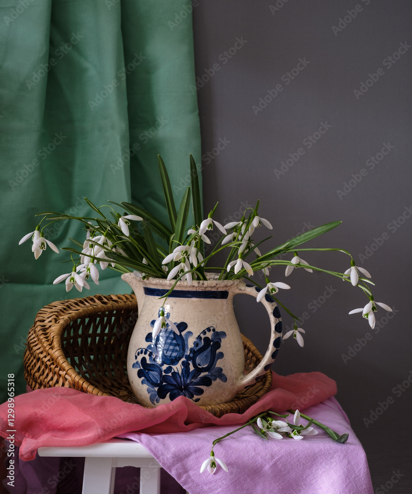 An Elegant Floral Arrangement Placed in a Ceramic Pitcher Surrounded by Beautiful Textiles